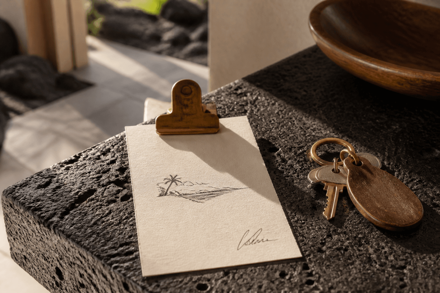 A brass clip holding a signed west-side quote on a Kona counter, lava stone, hard sun.
